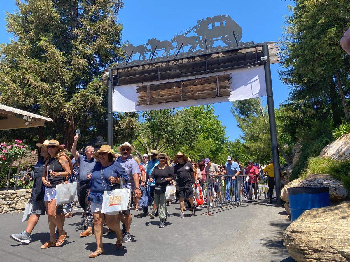 People flock into the Paso Wine Fest as the gates open at noon on Saturday. The festival moved to the Paso Robles Event Center for the first time this year.