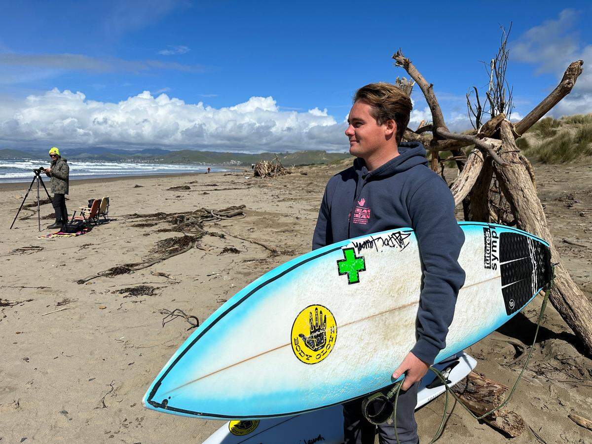 Tyler Gunter of Newport Beach prepares to compete in the SLO CAL Open surf competition in Morro Bay on Feb. 23, 2023 — a day that began with snow on the mountains overlooking the ocean.