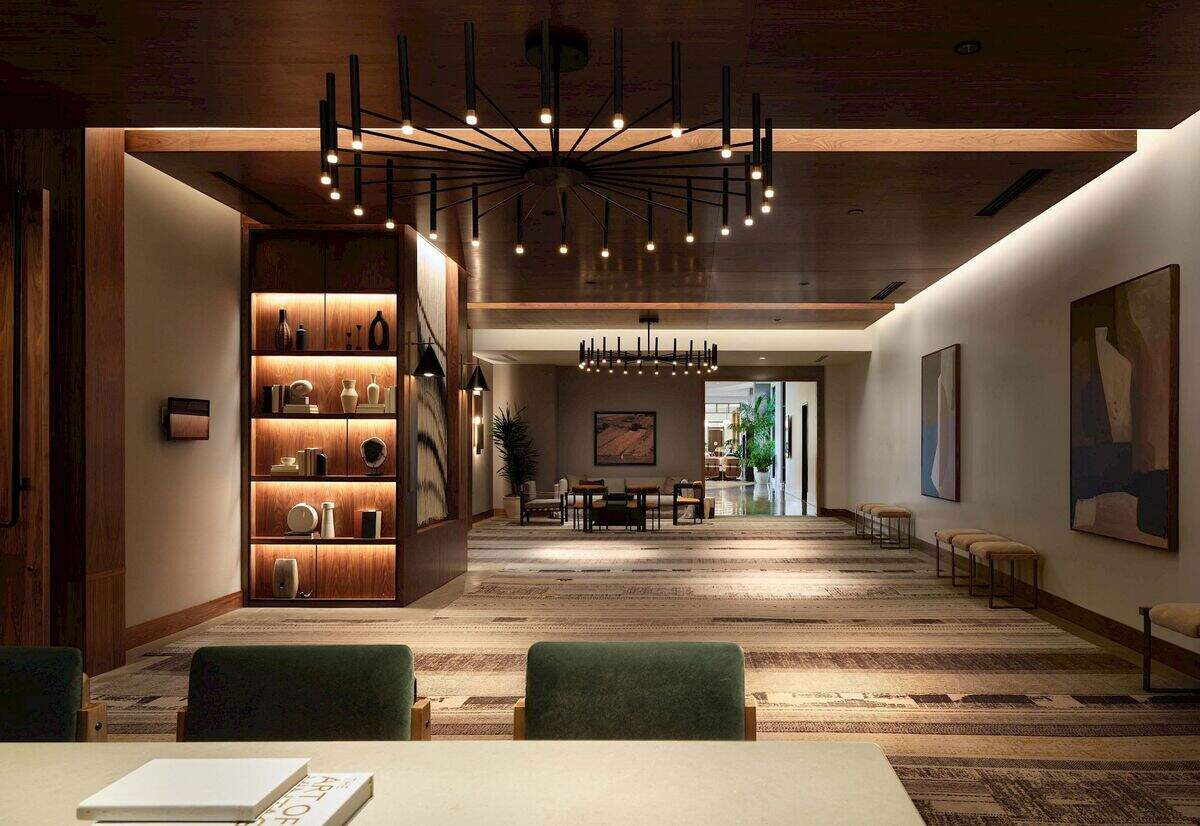 A view through The Ava Hotel’s lobby showcases the property’s contemporary design, with a dramatic chandelier, built-in bookcases and inviting gathering spaces that set the tone for the guest experience.