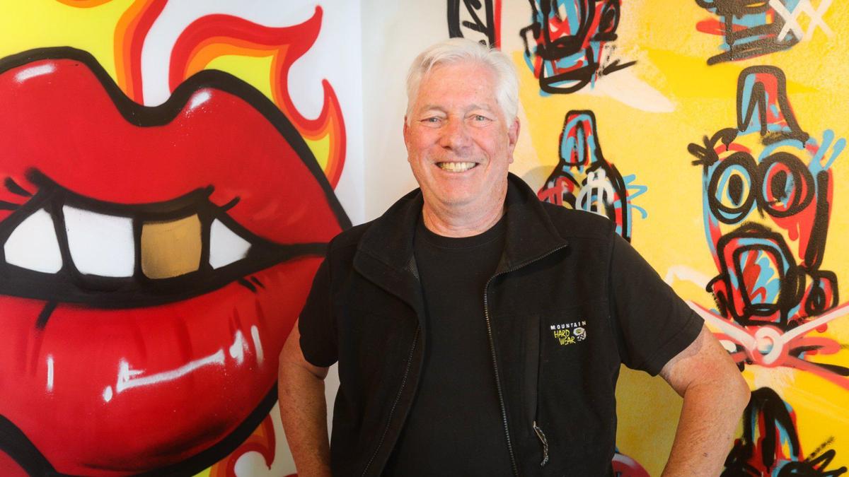 Co-owner Mitch Wolf stands in front of the street art that is part of the interior design at Dave’s Hot Chicken, now open in the former Panera location on Madonna Road in San Luis Obispo.