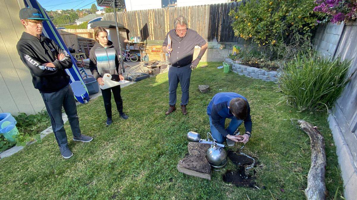 From left to right, Tim Nelligan’s two sons, Mason Nelligan and Jacob Nelligan, and Steve Hoyt watch Mark Mattison, one of Hoyt’s employees, insert a soil vapor probe and summa canister into the yard of Marcia Papich, which is adjacent to Susan Flores’ yard, in December 2020. They were testing for evidence of human decomposition in the search for Kristin Smart’s body.