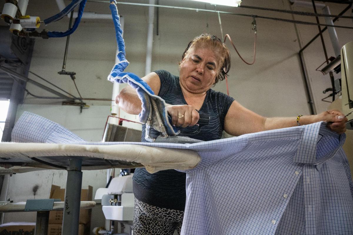 Patricia Hernandez irons a shirt at Prestige Cleaners in Sacramento on July 18, 2023.