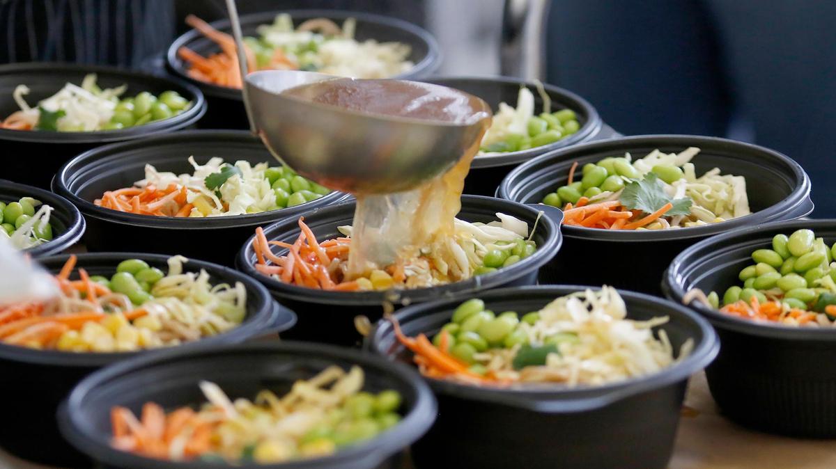 A food service worker pours warm broth over ramen and fresh vegetables at Flamson Junior High School in Paso Robles, where students enjoy from-scratch meals made with fresh ingredients from local farms and ranches.