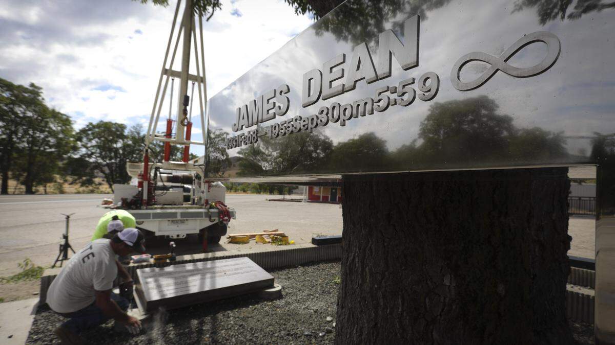 The James Dean monument in Cholame has been refreshed, chrome polished to original mirror finish seen here on Sept. 24, 2025. Seita Ohnishi sponsored the original monument in 1977, but it needed attention by 2024. The 70th anniversary of the fatal 1955 crash near the current intersection of Highways 46 and 41 will be on Sept. 30. Jared Toevs in foreground and Salvador Contreras install a new marker that Neil Sheehan sponsored. He led the effort to clean up the monument.
