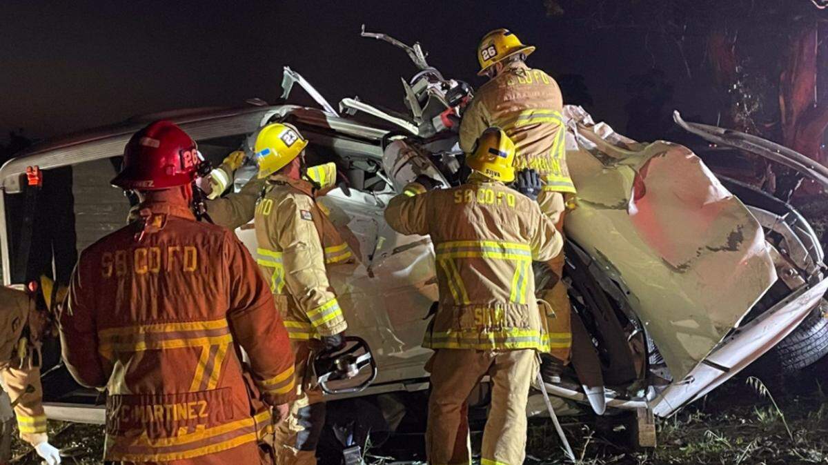 Firefighters work to extricate the body of a Santa Maria man who was killed Tuesday night in a single-vehicle crash on Highway 101 in Orcutt.