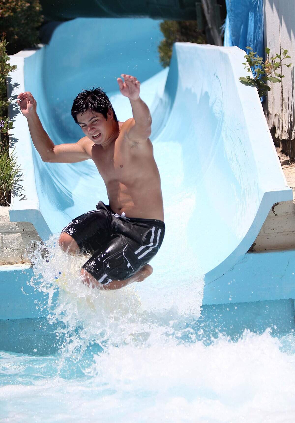 Mario Quiroga, 17, of Arroyo Grande water bombs at the end of the tunnel water slide at Mustang Waterpark at the Lopez Lake Recreation Area.