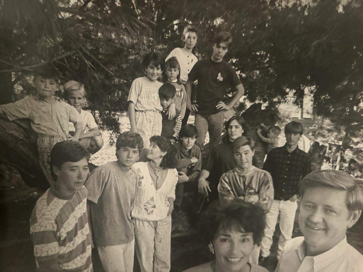 Luana and Jack Herlihy, bottom right, and 15 of their children in 1990. Luana Herlihy credits her husband for being supportive as their family grew to 19 children.