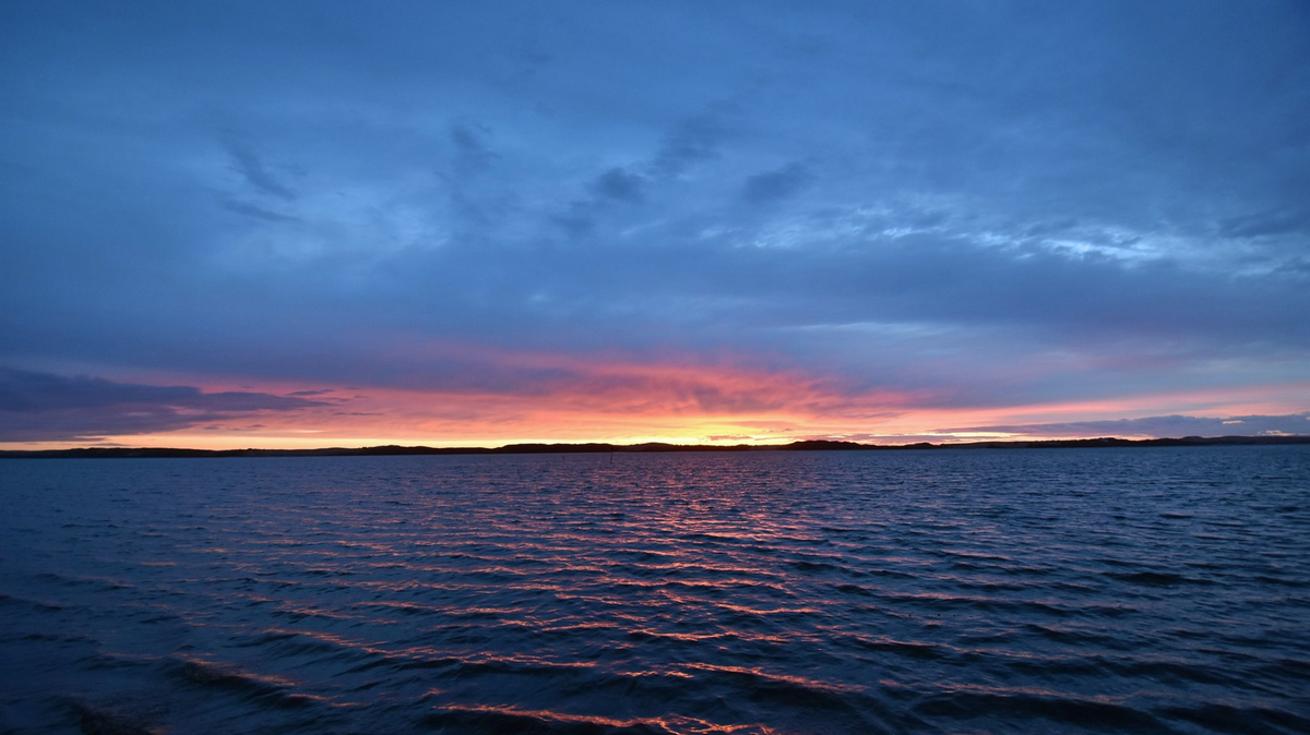 The sun sets over the Morro Bay Estuary in a view from Baywood Park.