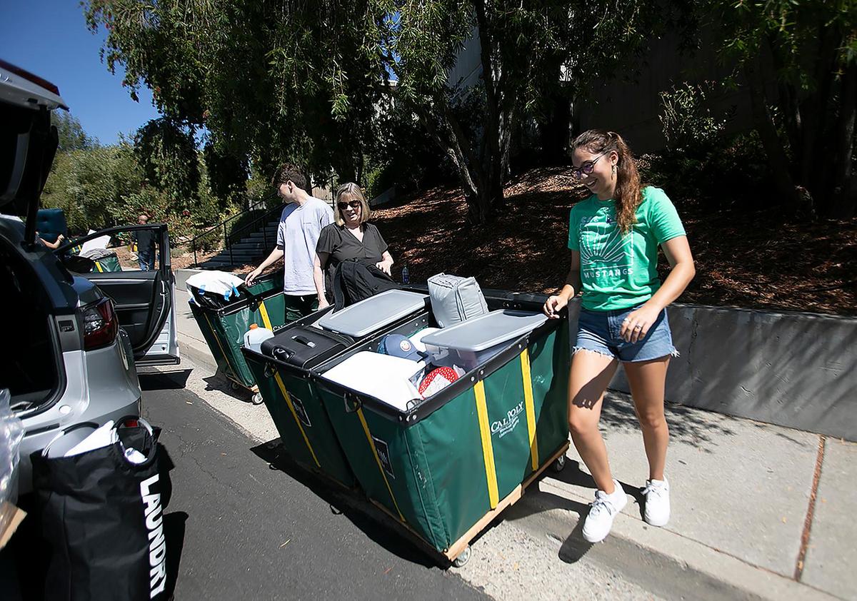 Cal Poly student Amalia Arndt helps Cindy Priscaro and Michael Priscaro, a marketing major, move the familiar green bins filled with Priscaro’s belongings into the dorms on Tuesday, Sept. 13, 2022, as the university’s new freshman class arrives on campus. The loading zone began at Grand Avenue and snaked around to the top level of the parking structure at the Performing Arts Center. After the new students move in, they’ll join their WOW groups on Wednesday evening for four days of orientation before classes begin next week.