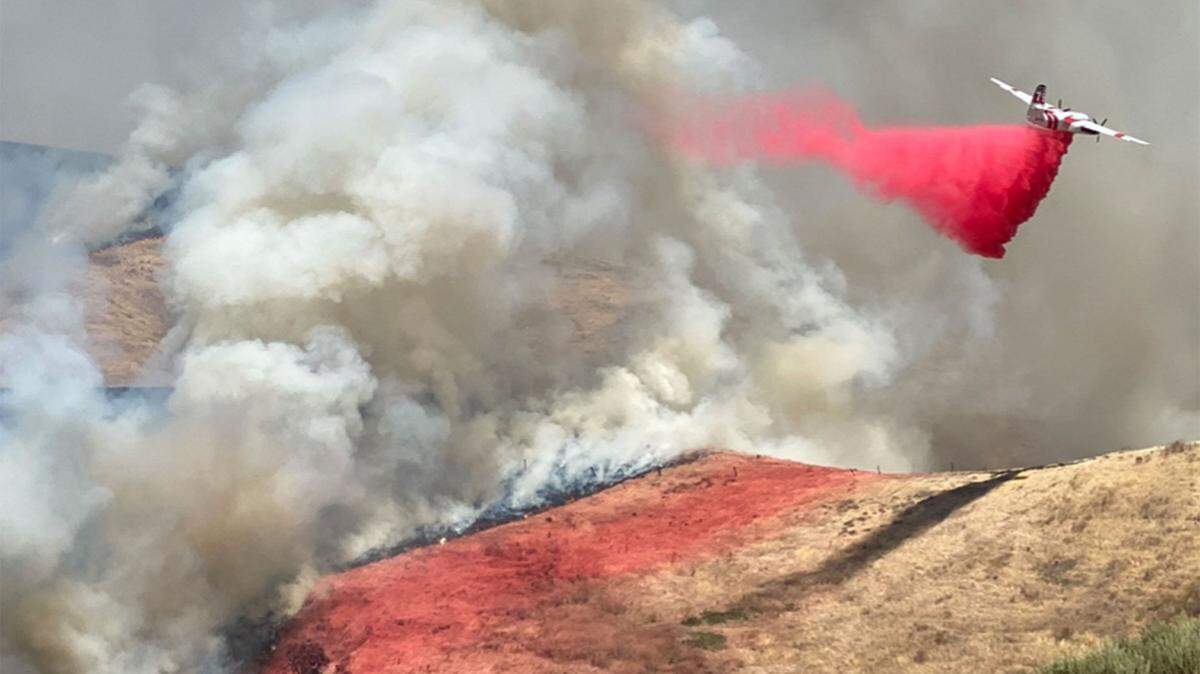 An air tanker makes a drop of retardant on a vegetation fire burning Sunday afternoon west of Buellton.