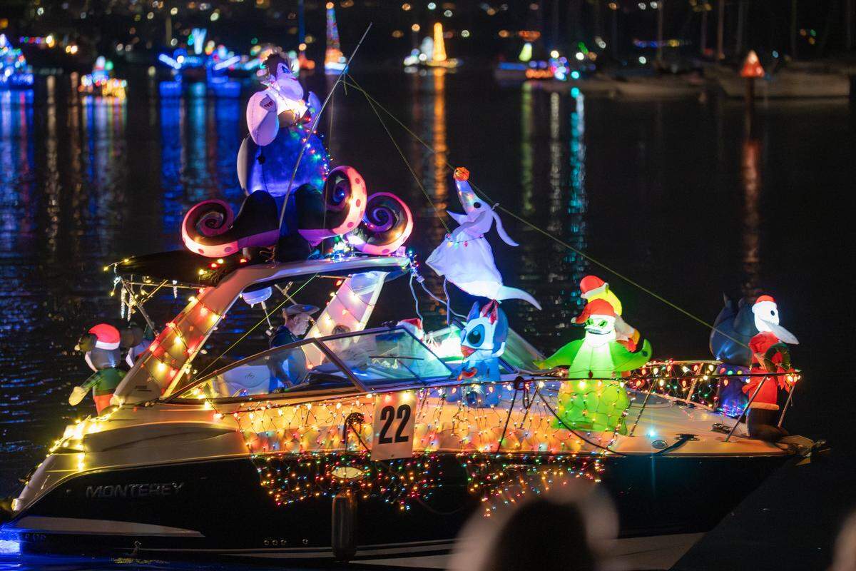 A small craft featuring multiple inflatable Disney characters passes the pier during the Morro Bay Lighted Boat Parade on Saturday, Dec. 13, 2025. The parade drew thousands of onlookers and dozens of boats equipped with festive lighting.