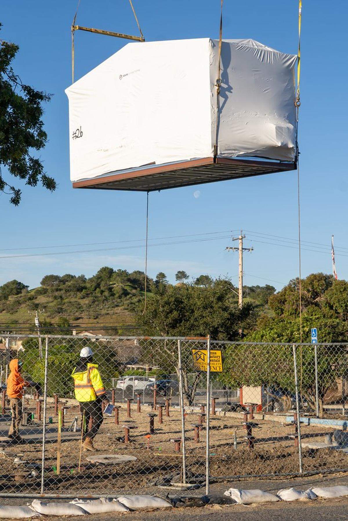 A prefabricated home is lowered by crane onto its ground screws at the Welcome Home Village on Thursday, Feb. 5, 2026. The Welcome Home Village will consist of 54 prefabricated, 3D-printed homes that will house homeless individuals.