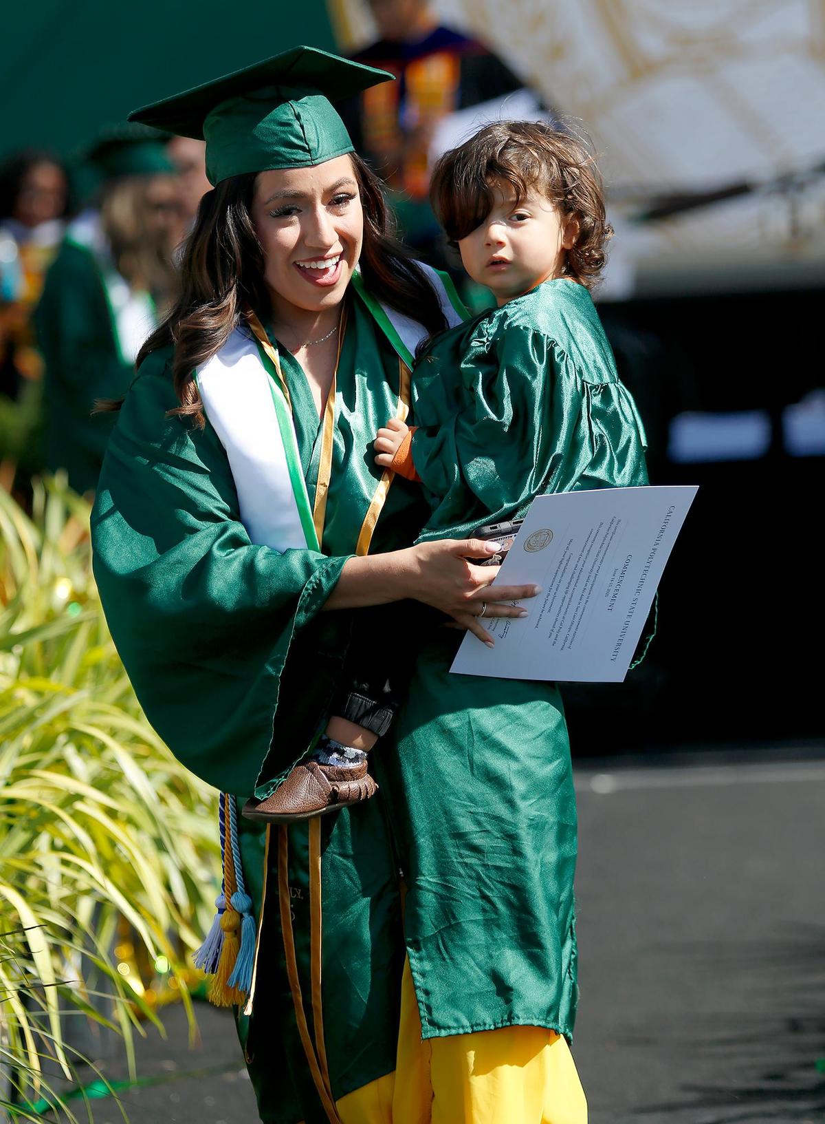 Several graduating students walked down the ramp with a child in their arms. Terri Valencia holds 1-year-old Benson Mendoza. Cal Poly in San Luis Obispo celebrated the Class of 2025 with commencement ceremonies the weekend of June 14, 2025. The university’s six colleges had a total of 6,821 graduates.