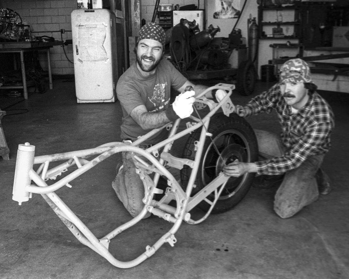 Allen Root, left, and Victor Rouse examine motorcycle frame for wheel fit on Feb. 2, 1982.