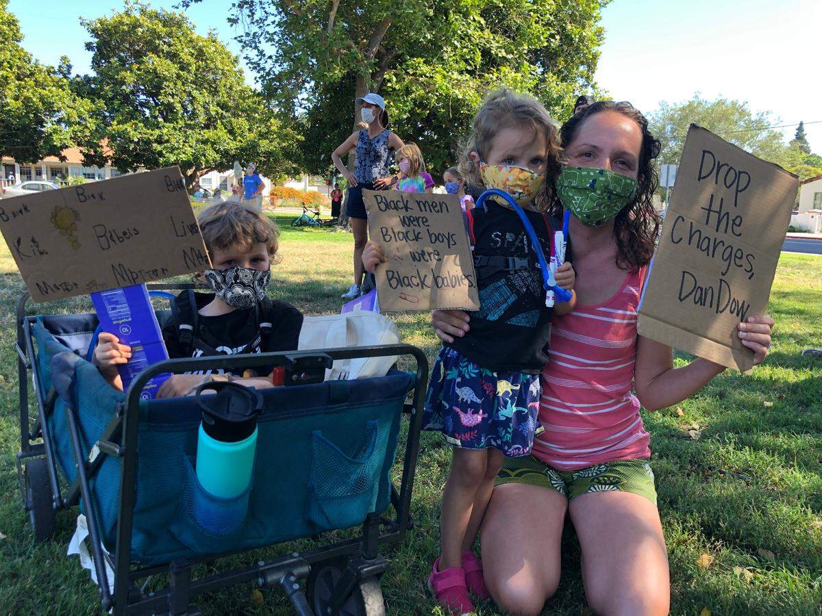 Erin Stehli, far right, and her kids, Everette, left, and Rosie, right, pose for a photo holding up signs they made for the Central Coast Children’s March for Black Lives.