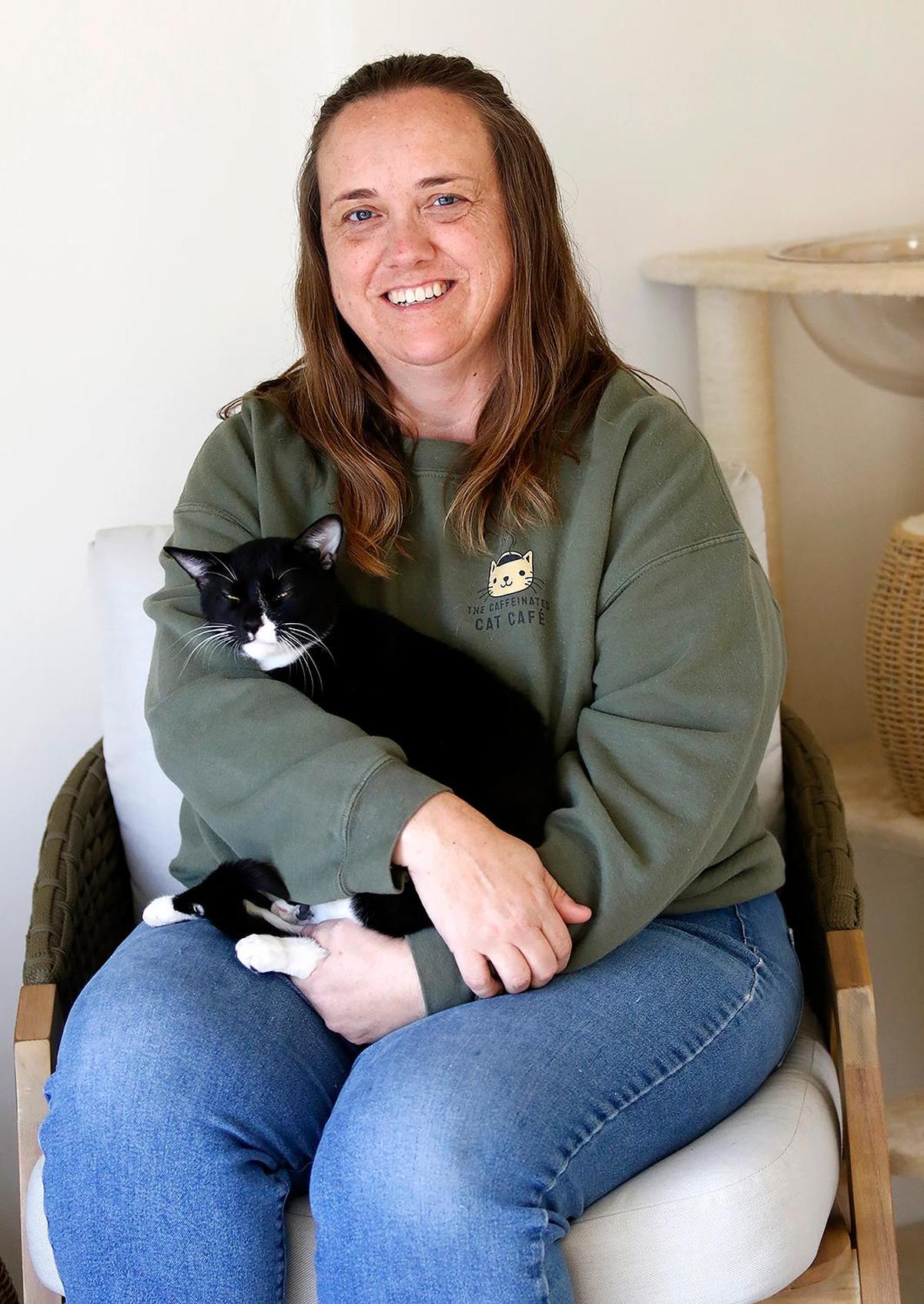 Caffeinated Cat Cafe owner, Jaime Pierce, holds a tuxedo cat named Arthur. The Caffeinated Cat Cafe hosted its grand opening in Grover Beach on Dec. 14, 2024, after over a year of trying to get the business up and running.