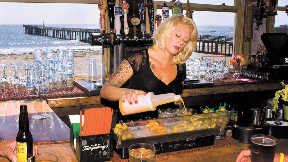 Molly McMinn mixes drinks at Schooners bar in Cayucos, which offers a view of the ocean and pier. For the third straight year, the Alcoholic Beverage Control company didn’t allow SLO County a new general alcohol license, meaning those who have them are in possession of valuable assets.
