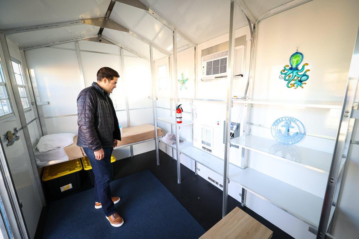 Supervisor Jimmy Paulding checks out one of the two-person pallet shelters at the 5Cities Homeless Coalition’s Cabins for Change campus in Grover Beach during a tour on Dec. 15, 2022. A bed folds down on either side.