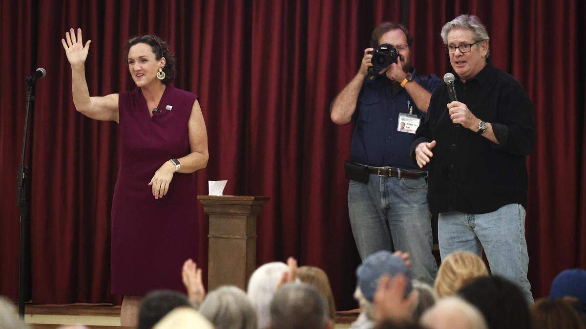 Katie Porter waves to the crowd as Tom Fulks, Chairman of the San Luis Obispo County Democratic Party, wraps up the meeting where she took questions from the audience in San Luis Obispo on April 3, 2026.