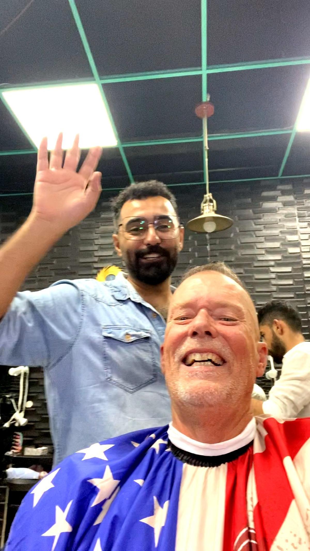 Ali Al-Shammari, cuts hair of Michael Reeves at Al-Shammari’s hair salon in Iraq. This is a screen capture from a selfie video sent to Linda Giordano, wife of Reeves.