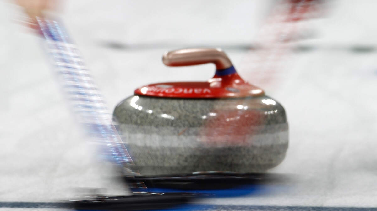 Members of the U.S. Curling Team clear the path for their rock in the women's match against China.  (Harry E. Walker/MCT)