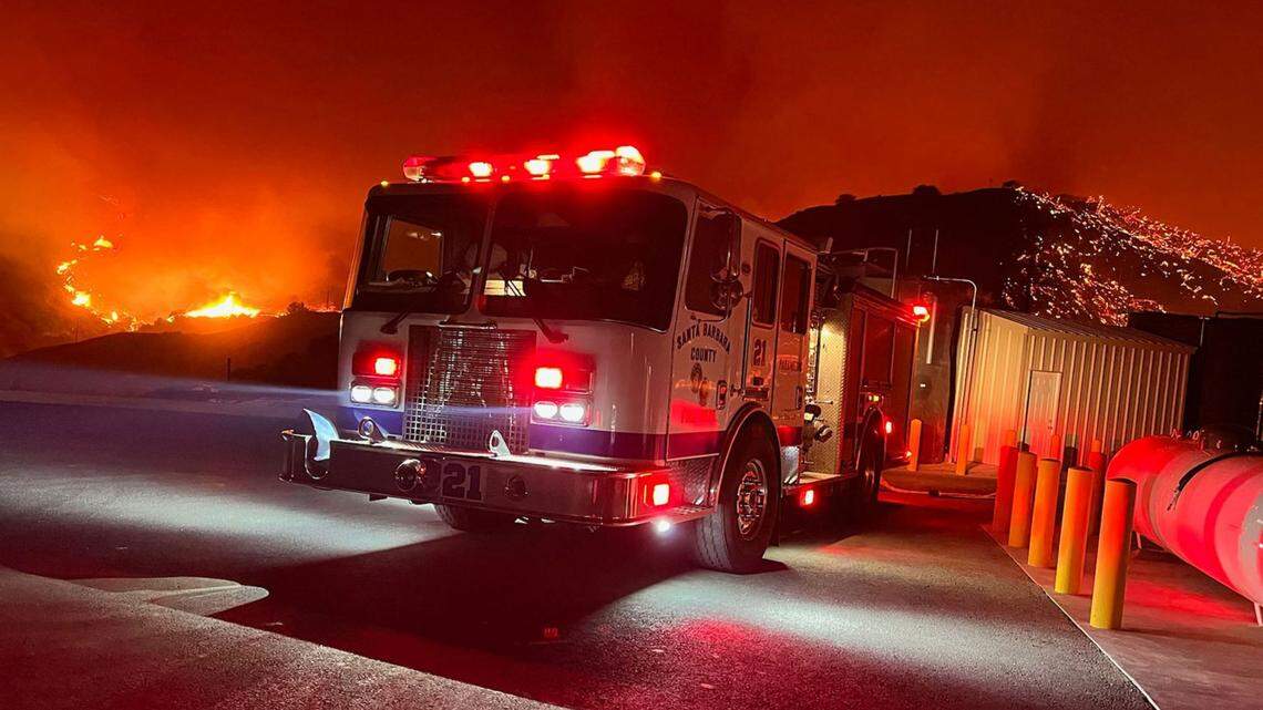 A Santa Barbara County fire engine does structure protection Monday night as the Alisal Fire continued to burn in the mountains along the Gaviota Coast.