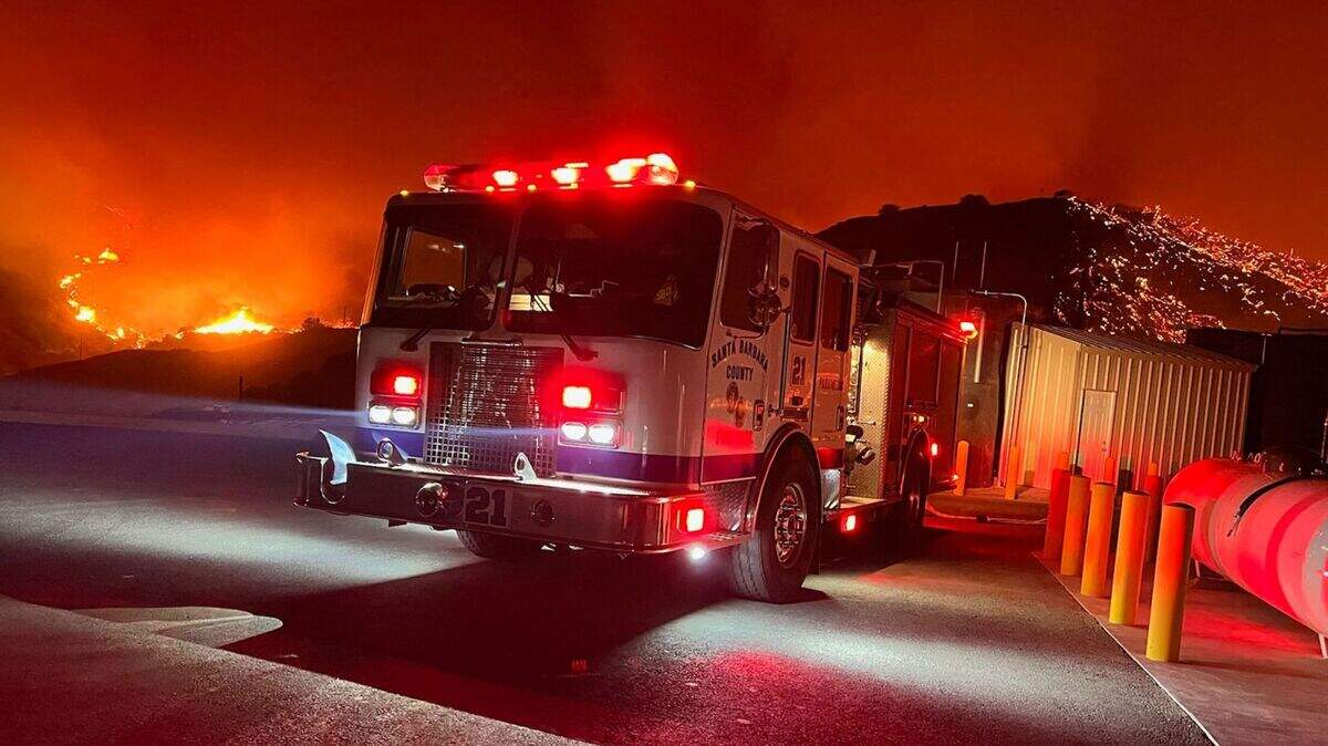 A Santa Barbara County fire engine does structure protection Monday night as the Alisal Fire continued to burn in the mountains along the Gaviota Coast.