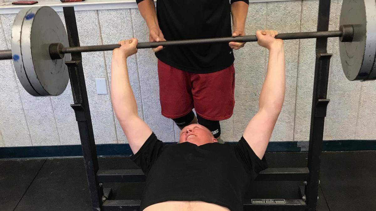 Incoming Coast Union High School senior lineman Spencer Magnuson bench presses 226 pounds; he is spotted by Broncos assistant football coach Trevor Near in the Coast Union weight room in mid-July. 
