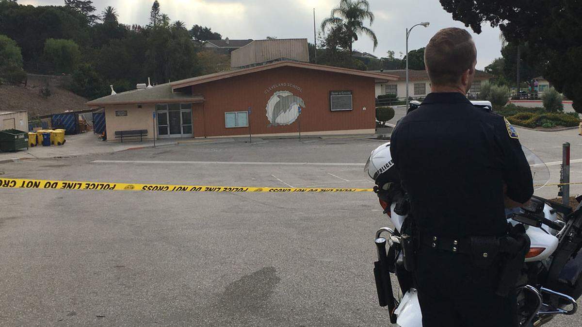 A Santa Barbara police officer stands guard Thursday outside Cleveland School in Santa Barbara, which was closed Thursday while detectives investigated a shooting that occurred there overnight.