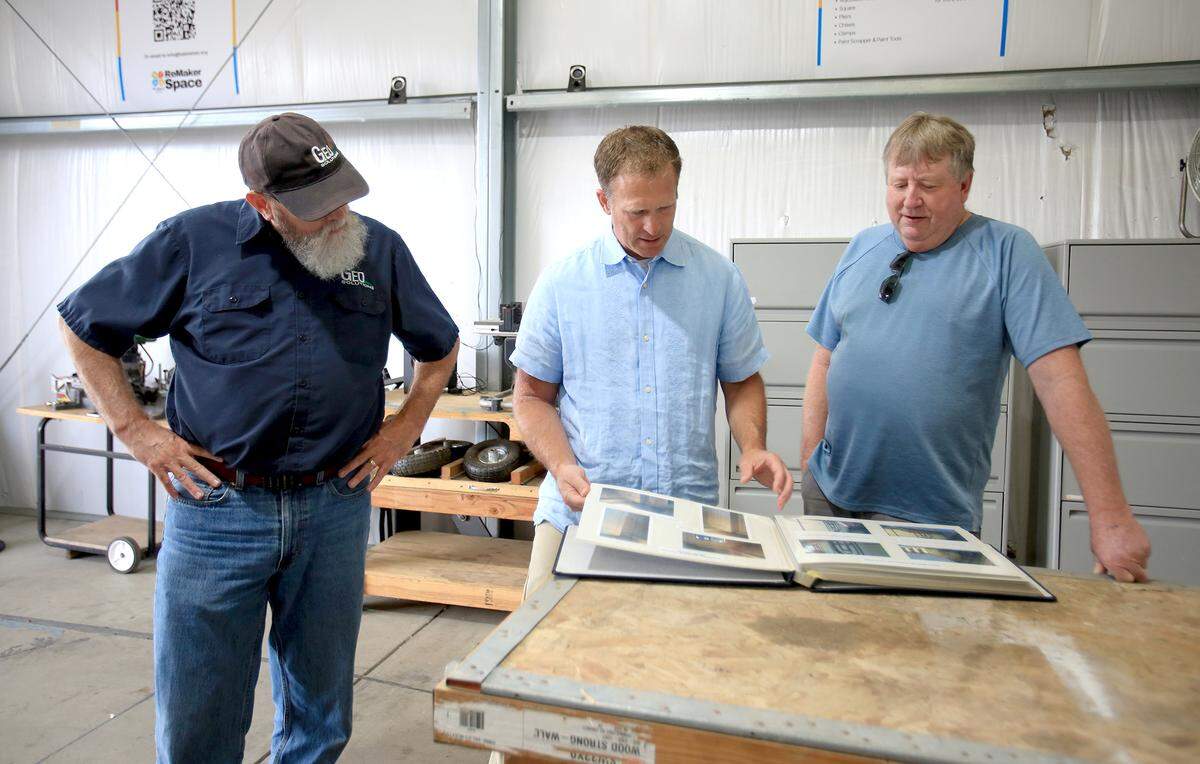 Board of directors for Habitat member, Craig Crozier, left, and board chair, Truitt Vance and potential volunteer Craig Mesman preview a book of photos of the new Remaker space. The new space will feature a fully equipped workshop with both hand and power tools.