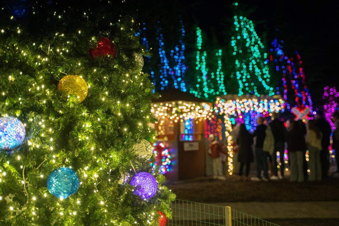 Ornaments glow on a Christmas tree as guests stand in line for a train ride at the Cambria Christmas Market on Friday, Nov. 21, 2025. The annual Christmas market will open its doors on Nov. 29, 2025.
