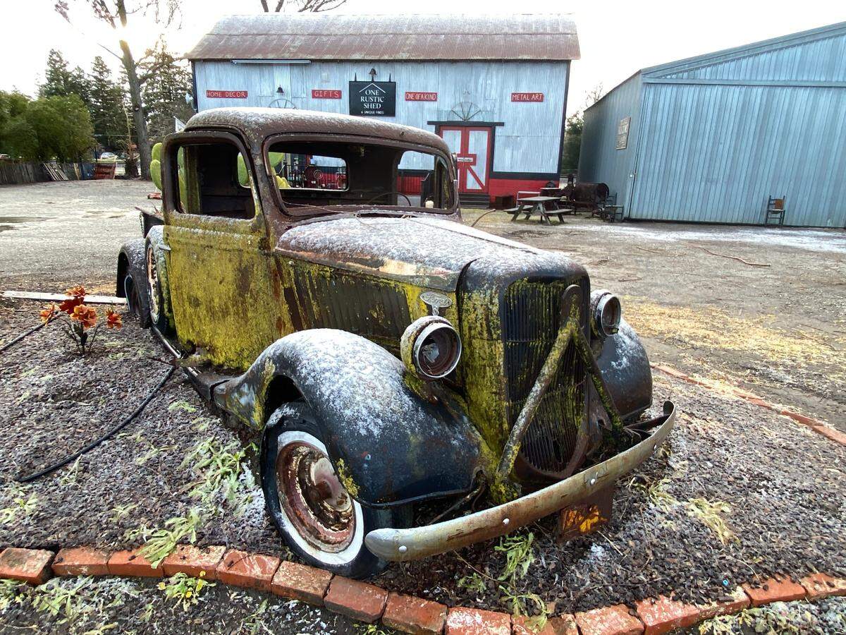 Snow dusts an old car at One Rustic Shed in Santa Margarita on Thursday, Feb. 23, 2023.