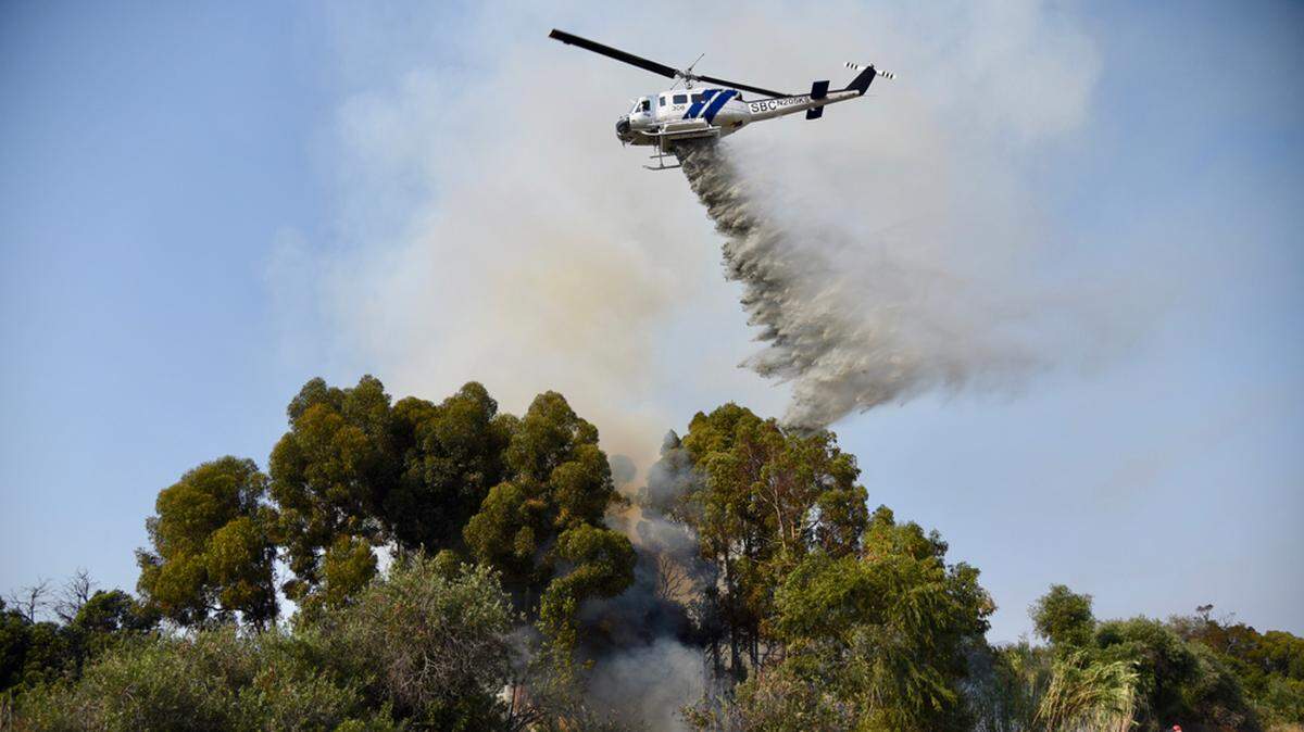 A Santa Barbara County helicopter drops water on a vegetation fire near the Goleta railroad tracks Friday.