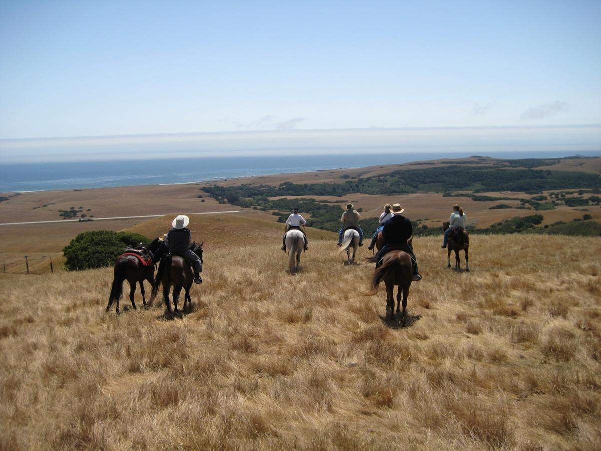 A group of friends rides on the 83,000-acre Hearst Ranch in San Simeon. William Randolph “Will” Hearst III is on the fourth horse from the left.
