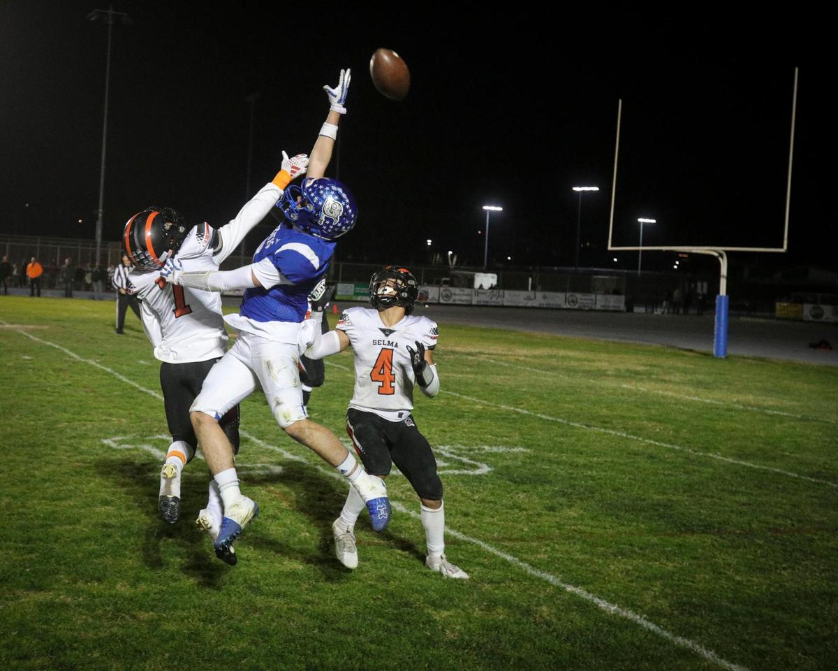 John Myers comes just short of catching a pass closely defended by Christian Hernandez left and Jacob Hernandez. Selma held off a last minute drive by Morro Bay to win the CIF Central Section Championship 32-28 on Nov. 27, 2024.