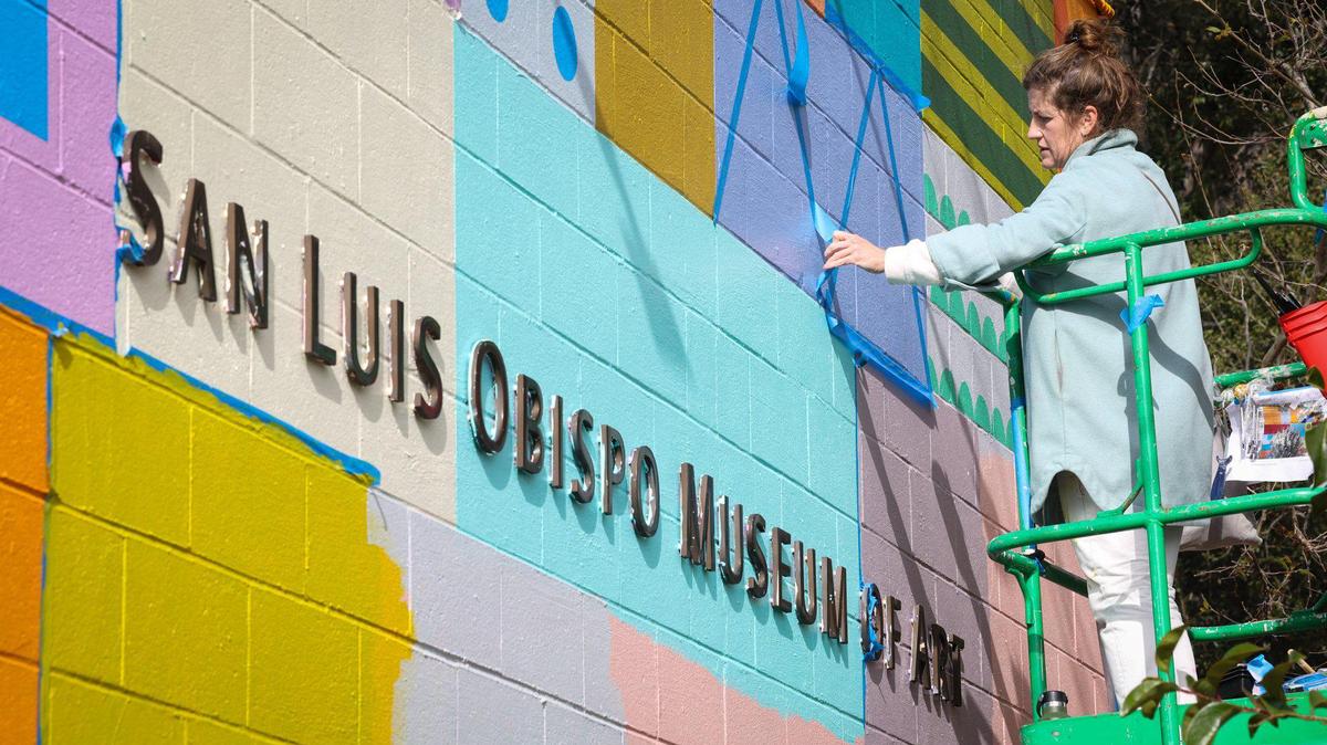 San Francisco artist Leah Rosenberg works on a new mural at the San Luis Obispo Museum of Art on Monday, Feb. 13, 2023. The museum is at risk of losing a three-year, $300,000 grant for its youth art education programs due to Trump administration funding cuts.