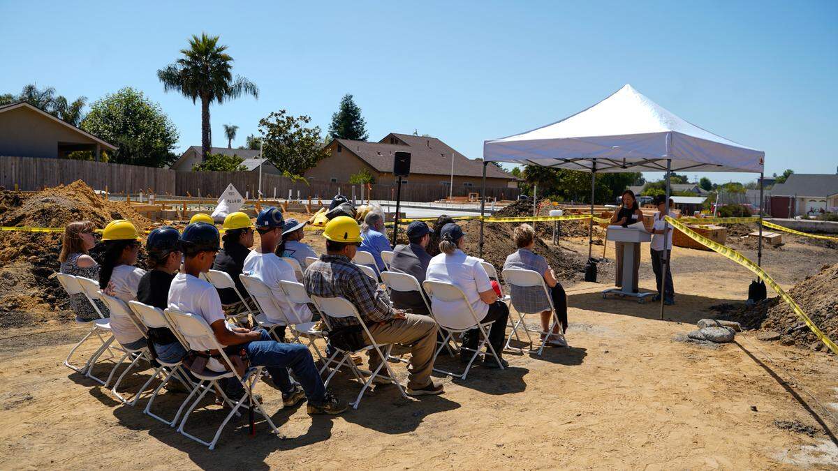 Future residents of Summer Holly Lane Homes listen to a presentation by People’s Self-Help Housing vice president of home ownership Sheryl Flores before a wall-raising ceremony. The 10-unit housing project in Nipomo will be built by its future residents, and is the first housing project in San Luis Obispo County to build residential homes on a commercially-zoned lot under the Workforce Housing Ordinance.