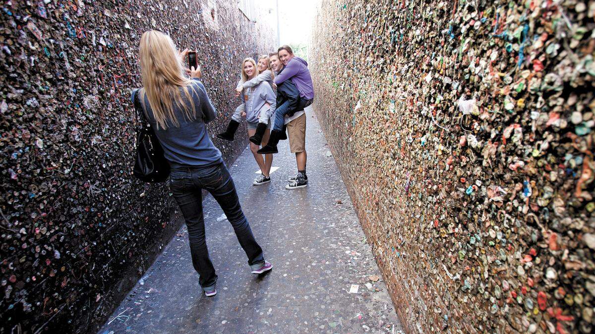 Visitors to San Luis Obispo take photos of themselves in Bubble Gum Alley on Sunday, Feb. 10, 2013. From left, Carie Mahlun takes photos of daughters Mattie, 18, and Jaycee Mahlun, 10. Also with them are Logan McQuay and Remi Mahlum, 15. They are all visiting from Clovis.