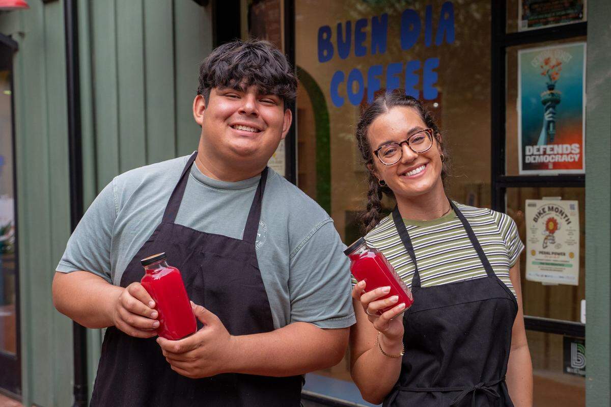 SLO Pressed kitchen manager Iker Ponce and owner Briana Medvecki hold bottles of their appleade juice in front of Buen Dia Coffee in San Luis Obispo on Thursday, May 14, 2026. Medvecki started pressing juice in 2025 as a way to treat acne and other skin irritations.