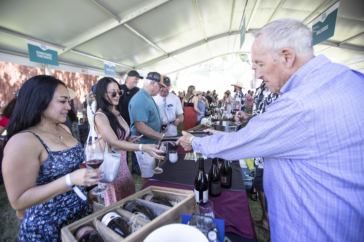 Patrick Faverty pours wine for Sabrina Cascigna, left, and Phi Markendorf, both of Bakersfield, at the Jack Creek Cellars booth during the Paso Wine Fest’s Grand Tasting on Saturday, May 20, 2023.