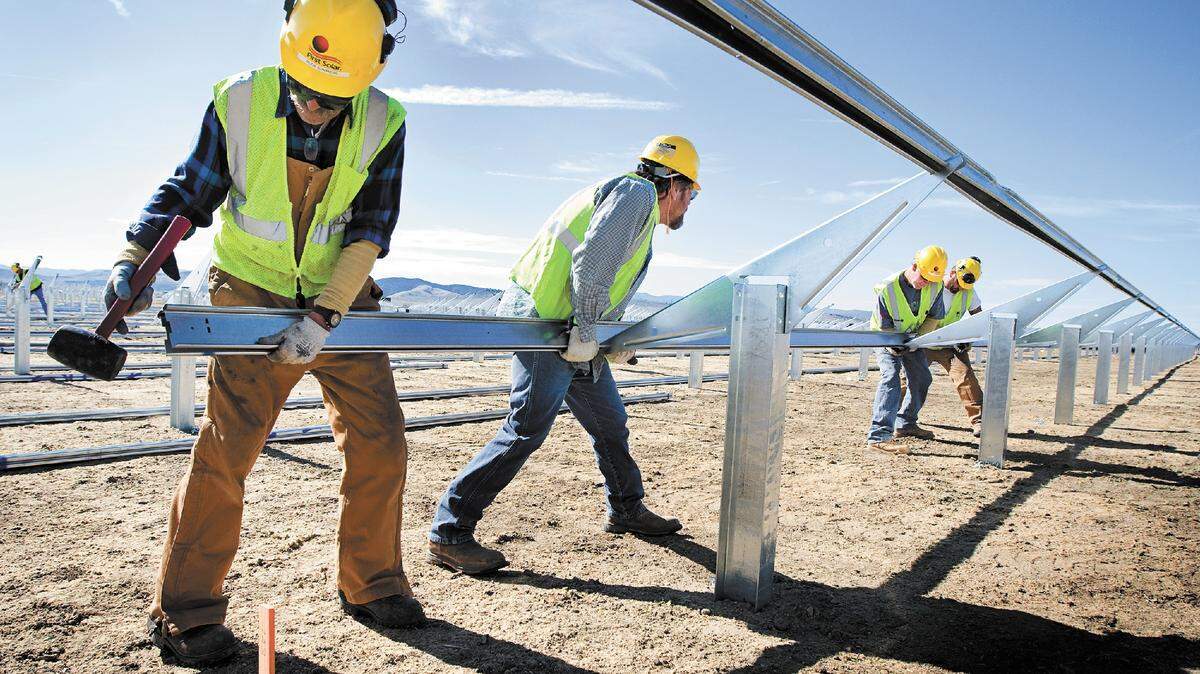 A construction crew installs the rails that will support the solar panels at the Topaz Solar Farm in California Valley in February 2012.