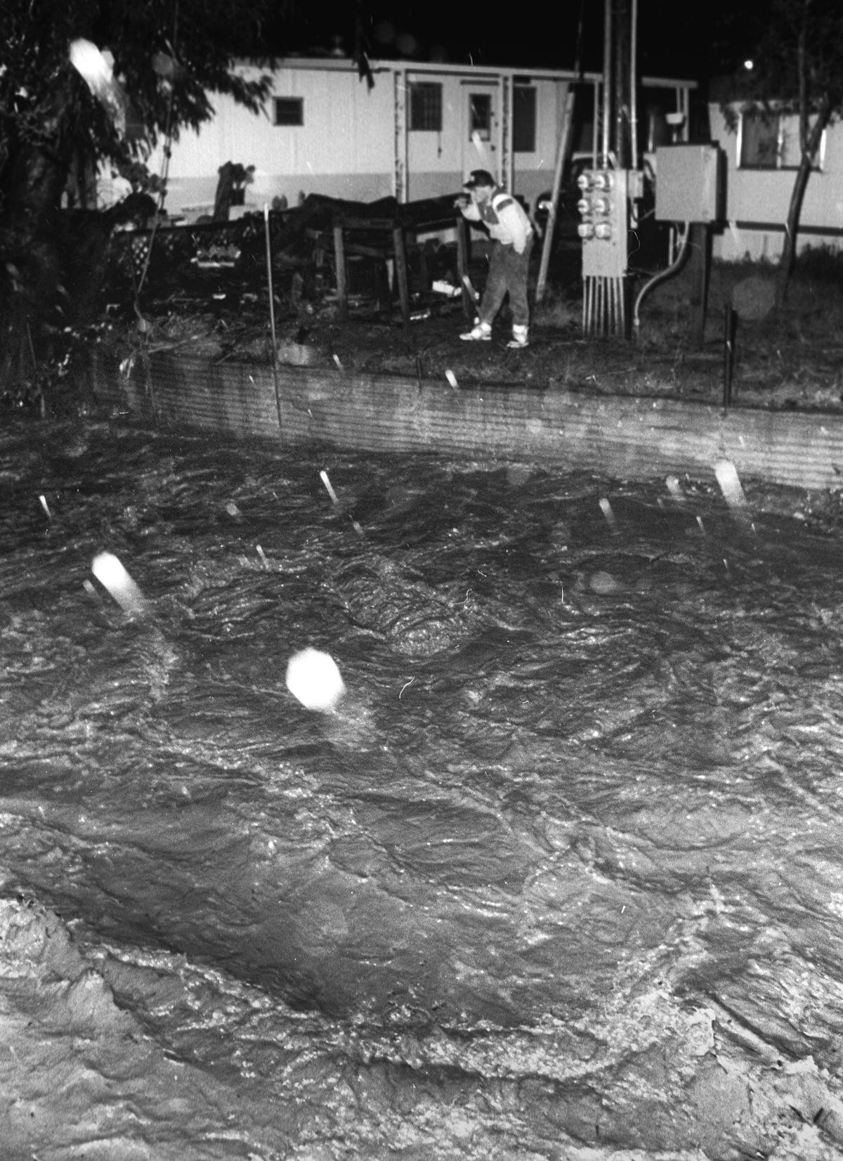 Cal Poly student Toiny Hover watches San Luis Creek rise behind his trailer the evening of March 18, 1991. David Middlecamp
