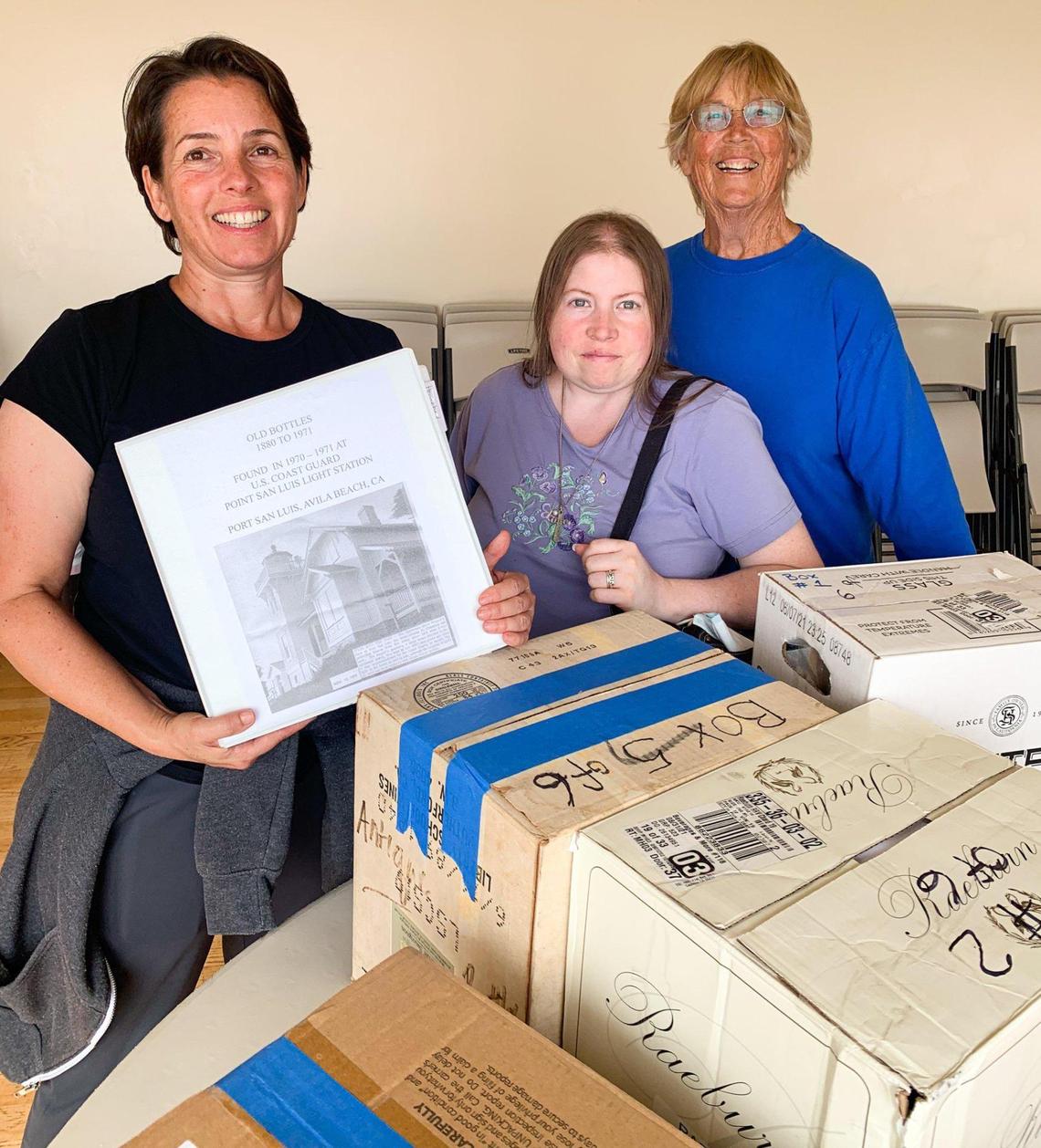 Three members of Richard Guizio’s family — daughter Dona Guizio, granddaughter Bridgette Grever and wife Mary Guzio — bring 100 bottles and a binder filled with research to the Point San Luis Lighthouse. The late U.S. Coast Guard officer uncovered the bottles more than five decades ago in a former garbage pit.