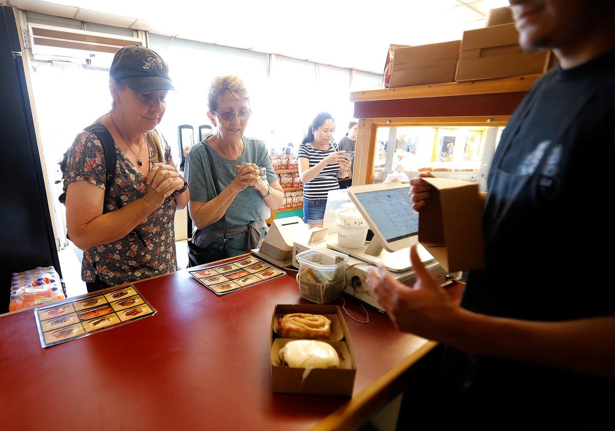 Two diners wait with anticipation for their treats at Old West Cinnamon Rolls in Pismo Beach.