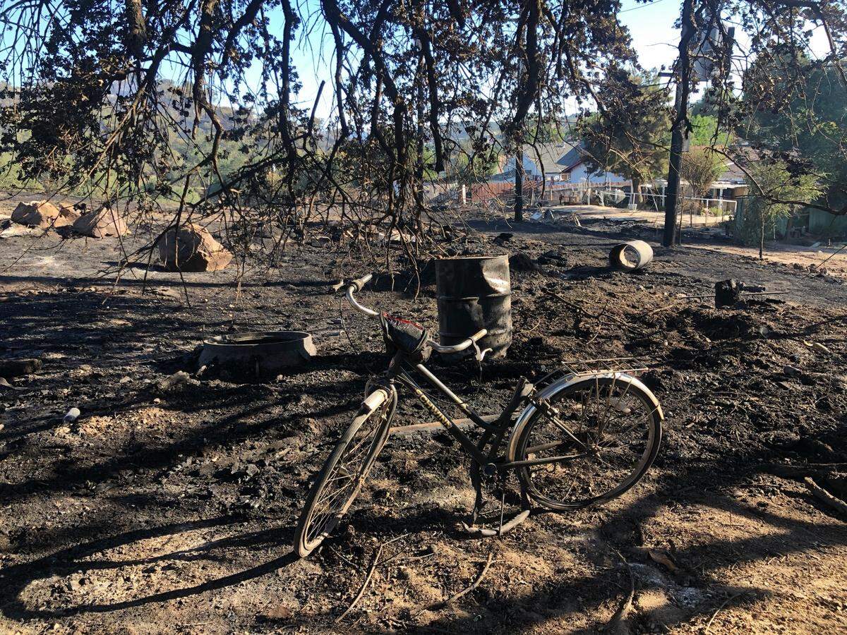 A bike stands on a scorched lot after the River Fire burned through a neighborhood in Paso Robles on Monday.