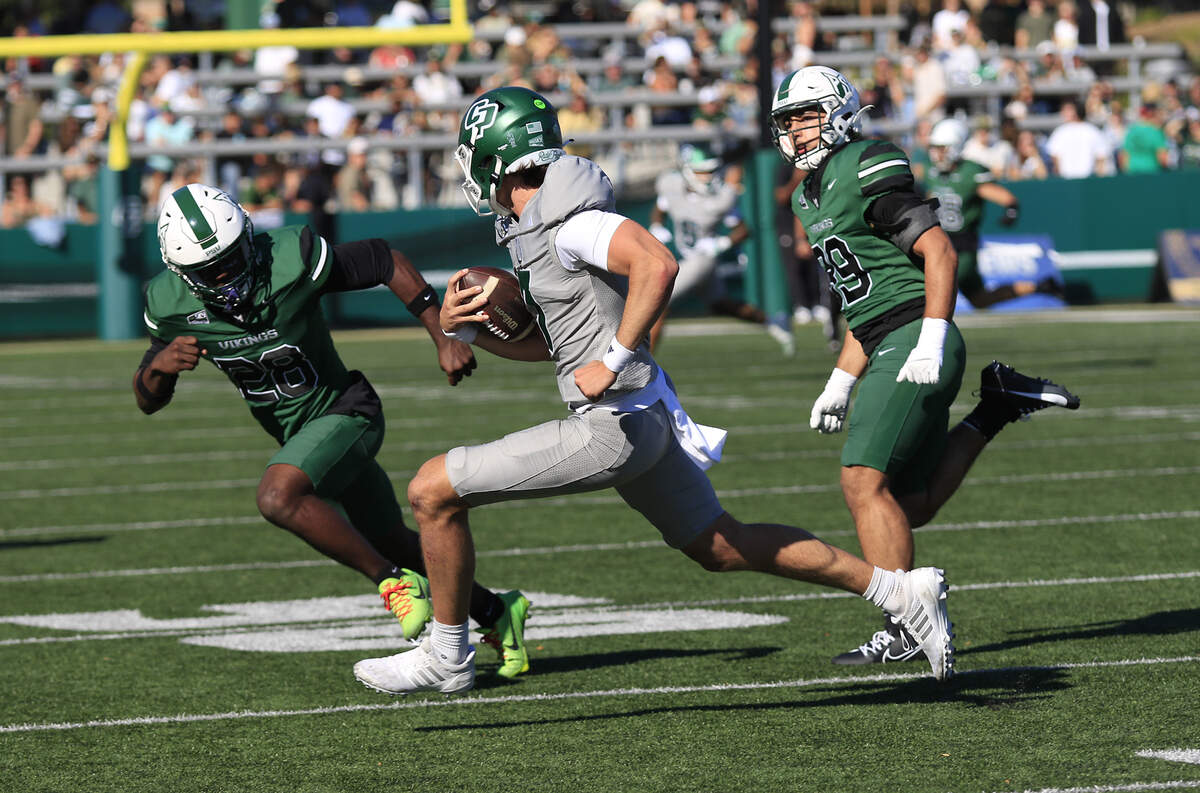 Mustang quarterback Ty Diffenbach runs a play under pressure from the Viking defense.. Cal Poly fell to Portland State 40-35 in a college football game at Mustang Memorial Field on Nov. 1, 2025.
