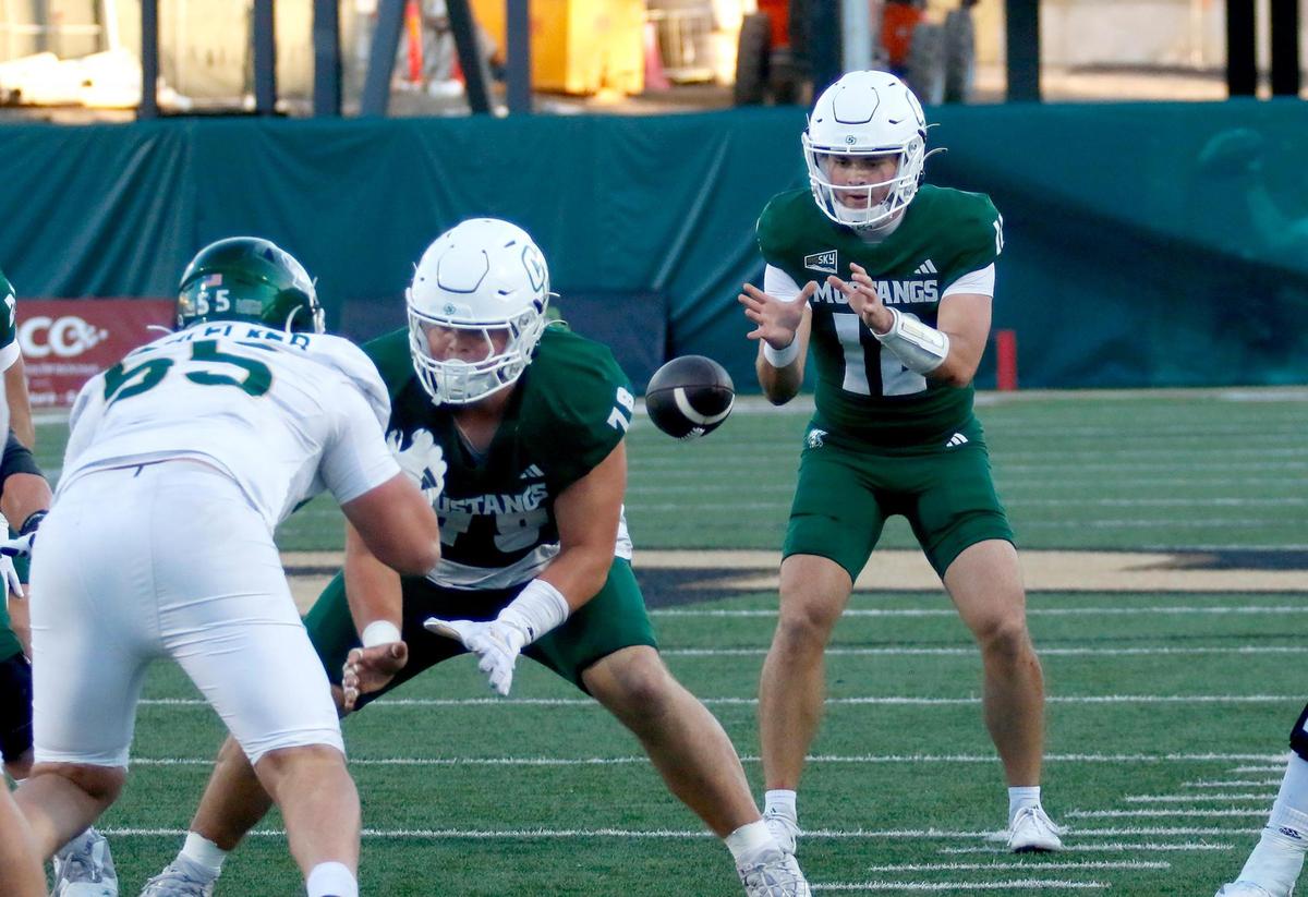The ball is hiked to Cal Poly quarterback Jackson Akins. Cal Poly beat Sacramento State 26-23 in a college football game at Mustang Memorial Field on Nov. 16, 2024.