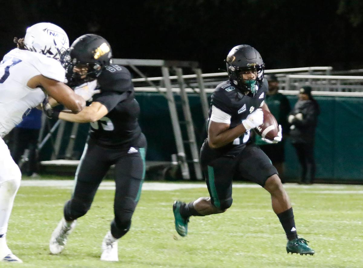 Cal Poly’s Zion Hall (19) carries the ball past a block by Cooper Galloway (85). In its season finale, Cal Poly fell to Northern Arizona 45-21 at Alex G. Spanos Stadium in San Luis Obispo, on Saturday, Nov. 20, 2021.