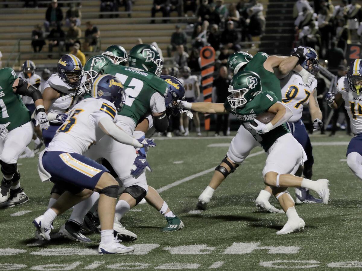 Cal Poly running back Aiden Ramos gets protected by Payson Campisano. Cal Poly lost to Northern Arizona 31–14 in a college football game at Mustang Memorial Field on Nov. 9, 2024.