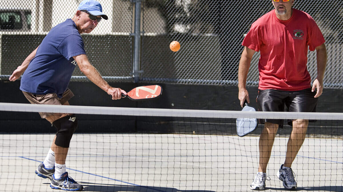 Dick Beiden, left, and Doug Bates play a doubles game of pickleball, using a portable net, at the old roller hockey rink at Centennial Park. The Paso Robles Pickleball Club is holding a fundraiser to build a permanent pickleball court in the space.